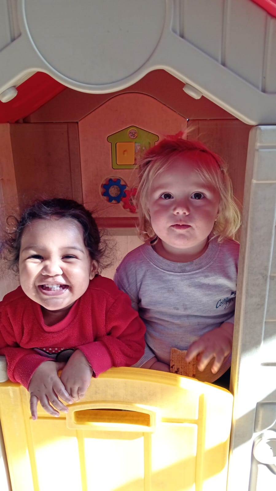 Two children smiling in the playhouse