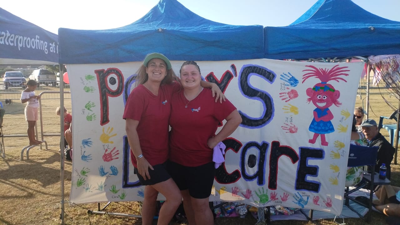 Our team in front of the Poppy's Daycare banner